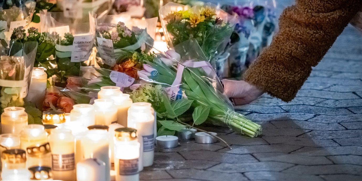 Blommor och ljus vid en butik på Bellevuegården i Malmö på onsdagskvällen efter att en kvinna i 50-årsåldern knivhuggits till döds på förmiddagen.
