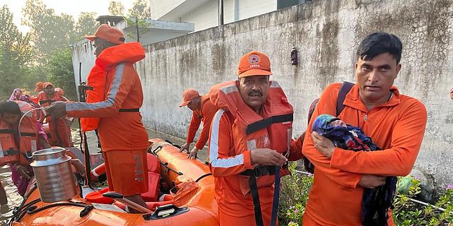 Räddningstjänst räddar en bäbis i monsundrabbade delstaten Himachal Pradesh. AP
