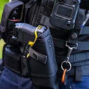 En polis med ett elchocksvapen. Arkivbild. 