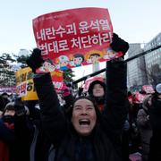 En demonstrant firar efter beskedet att Yoon Suk-Yeol stängs av från presidentämbetet. 