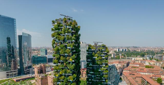 Aerial view of modern and ecologic skyscrapers in Italy, Milan. Vertical forest also called Bosco Verticale residential buildings with many trees and plants in balconies. Audrius Venclova/Shutterstock