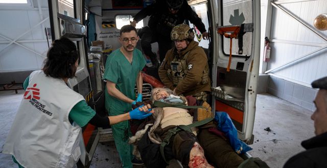 En skadad kvinna flyttas av ambulanspersonal efter att hennes bostadshus i ukrainska Kostiantinivka bombats, 10 mars 2023.  Evgeniy Maloletka / AP