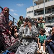 Palestinsk kvinna ledsen över att behöva evakueras från den skola där hon sökt skydd.