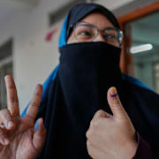 En kvinna i huvudstaden Dhaka visar bläckmärket på tummen som visar att hon har röstat.