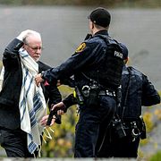 Polisen pratar med en man efter skjutningen.