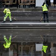 Två personer städar trappen vid Kungsträdgårdens damm i Stockholm.