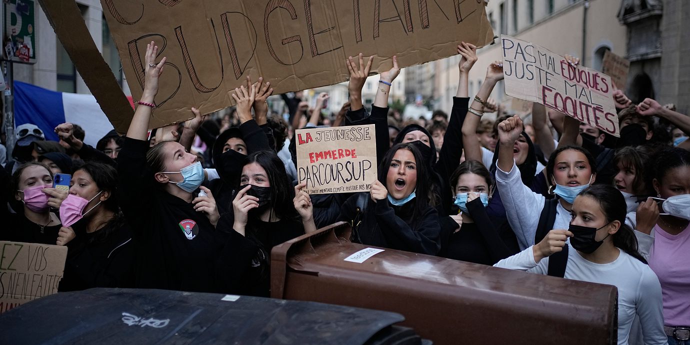 Studenter håller upp plakat vid en demonstration.