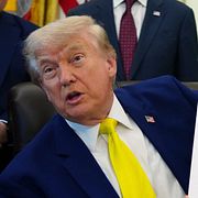 President Donald Trump håller upp en bild som illustrerar Lincoln Memorial-poolen.