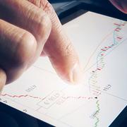 Stock broker holding tablet with candle stick graph. Trading stocks online.