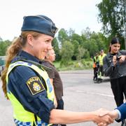 Johansson hälsar på polis på plats i Broddbo på onsdagen.