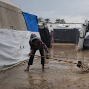 Samar Fayyad, 12, försöker få bort vatten efter en översvämning i hennes tältläger i slutet av november.