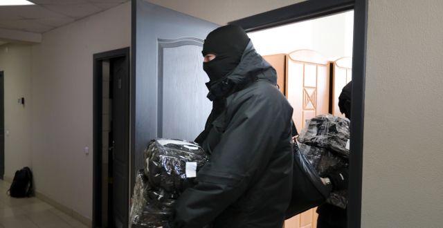 Poliser bär ut datorer och dokument från Journalistförbundet i Minsk. TT NYHETSBYRÅN