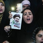 Irans kvinna håller upp bild på Mojtaba Khamenei, arkivbild från 4 maj.