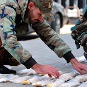 In this photo released by the Syrian official news agency SANA, a Syrian soldier displays Captagon pills, in rural Damascus, Syria, Tuesday, Nov. 30, 2021. 