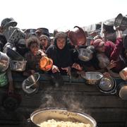 Palestinier i Gaza i väntan på donerad mat. 