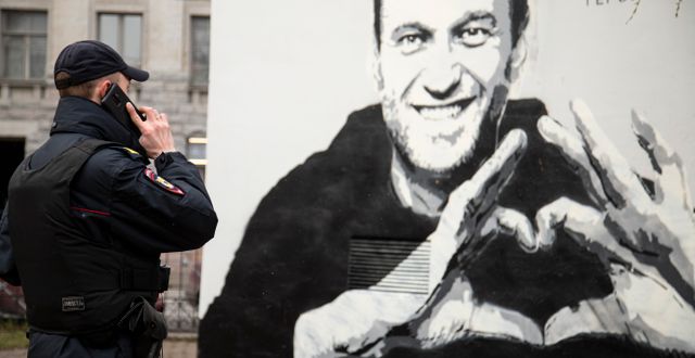 Polis framför en grafittimålning föreställande Navalnyj. Ivan Petrov / TT NYHETSBYRÅN