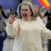 En kvinna talar med sitt barnbarn på Facetime på en flygplats i USA.