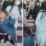 En liten flicka blir knuffad på det kända övergångsstället i Japan