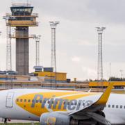 Ett flygplan landar på Malmö Airport med flygtornet i bakgrunden.