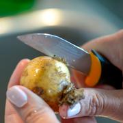 
En kvinna skalar färskpotatis med en kniv. Fel, enligt potatisexperten Stefan Ekengren. 