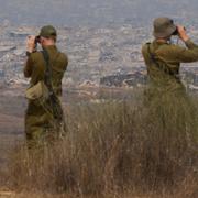 Arkivbild på israeliska soldater som ser ut över Gaza.