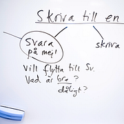 Simona Mohamsson (L) och en whiteboardtavla under SFI-lektion i Tomelilla.