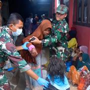 Indonesiska soldater tar hand om kvinnor och barn som räddats från fartyget.