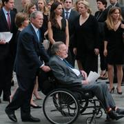 George H W Bush får hjälp av sin son, George W Bush, i samband med hustruns begravning