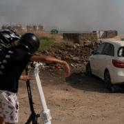 Barn i Katsrin, Israel tittar på en förstörd bil efter libanesisk beskjutning den 13 juni 2024.