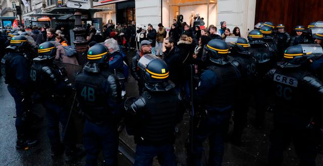 Strejkande anställda hos kollektivtrafiken omringas av kravallpolis i Paris. FRANCOIS GUILLOT / AFP