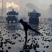 En demonstrant kastar gatsten mot polis i Tirana under lördagen.