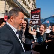 En aktieägare försöker att gå in på oljejätten Totals bolagsstämma och möts av klimatdemonstranters protester.