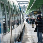 Passagerare väntar på pendeltåg på Kallhälls station  