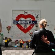 Människor sörjer de som omkom i branden i Grenfell Tower på årsdagen i juni.