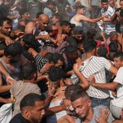 Palestinier kämpar för att samla in humanitärt bistånd som släppts ned med fallskärmar i Gaza City den 14 augusti.