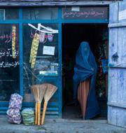 An Afghan woman wearing a burka exits a small shop in Kabul, Afghanistan, Sunday, Dec. 5, 2021. 