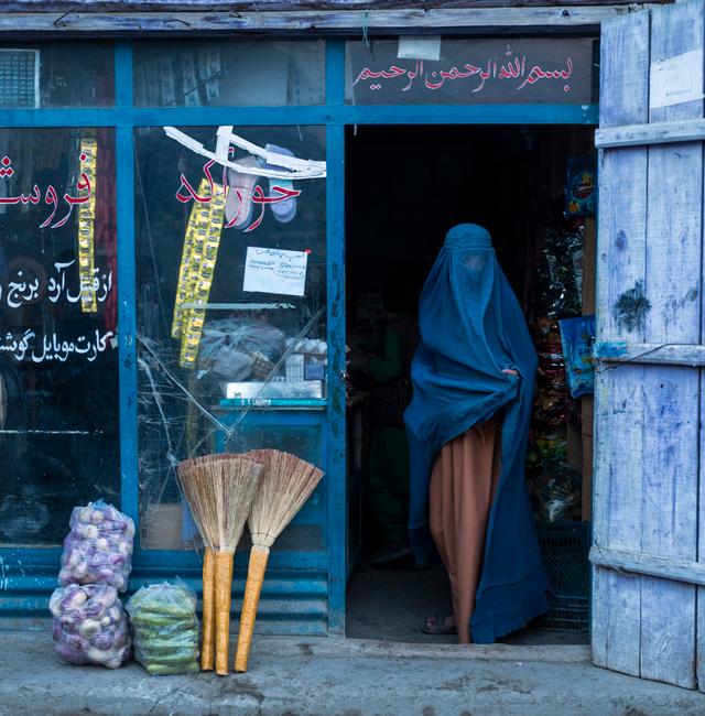 An Afghan woman wearing a burka exits a small shop in Kabul, Afghanistan, Sunday, Dec. 5, 2021.  Petros Giannakouris / AP