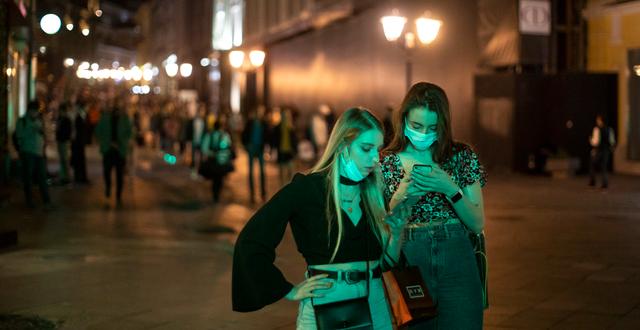Två kvinnor läser på en mobil i centrala Moskva, arkivbild. Alexander Zemlianichenko / AP