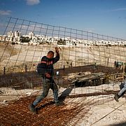 Arkivfoto: Palestinska byggnadsarbetare bär byggnadsmaterial i den israeliska bosättningen Ma’ale Adumim på den ockuperade palestinska Västbanken den 22 januari 2017. 