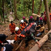 Räddningsarbetare bär ut en död kropp efter gruvkollapsen på ön Sulawesi. 