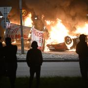 En banderoll med texten "Nej till koranbränning. Missbruka ej yttrandefriheten" under nattens bilbränder i Malmö.