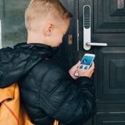 Pojke öppnar dörr med ”smart locks”.