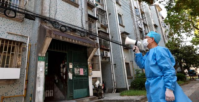 Shanghai, 12 april. En volontär pratar med invånare i husarrest genom en megafon. Chen Jianli / AP