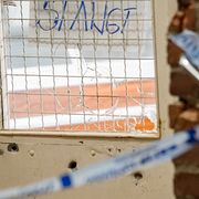 Polisens avspärrningar och ett 10-tal kulhål i den trappuppgång i centrala Landskrona där skjutningen ägde rum.