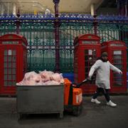 Man med en låda med kött på Smithfield Market i London. 