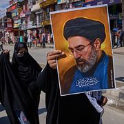 Demonstranter håller upp Mojtaba Khameneis porträtt.