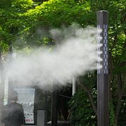 En man kyler sig framför maskiner som står utplacerade i Seoul för att sprida svalkande vattenånga.
