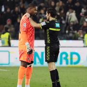 Referee Enzo Maresca, right, speaks to AC Milan's Mike Maignan. 