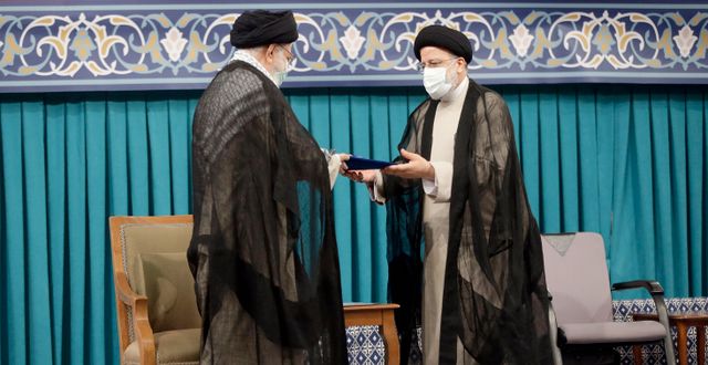Ebrahim Raisi (höger) tar emot det officiella godkännande till sin nya post från Irans högsta ledare Ayatollah Ali Khamenei (vänster) TT NYHETSBYRÅN