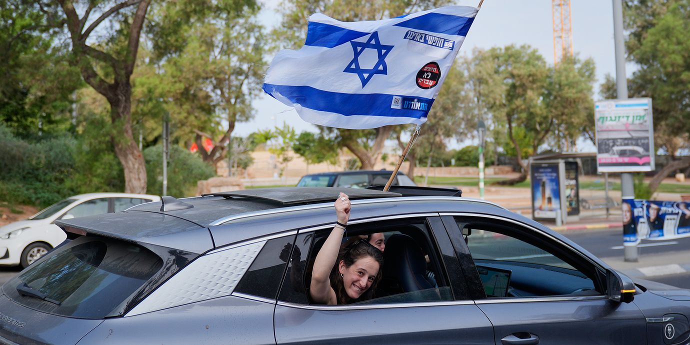 En kvinna viftar med en israelisk flagga från ett bilfönster under valdagen i Tel Aviv på tisdagen.